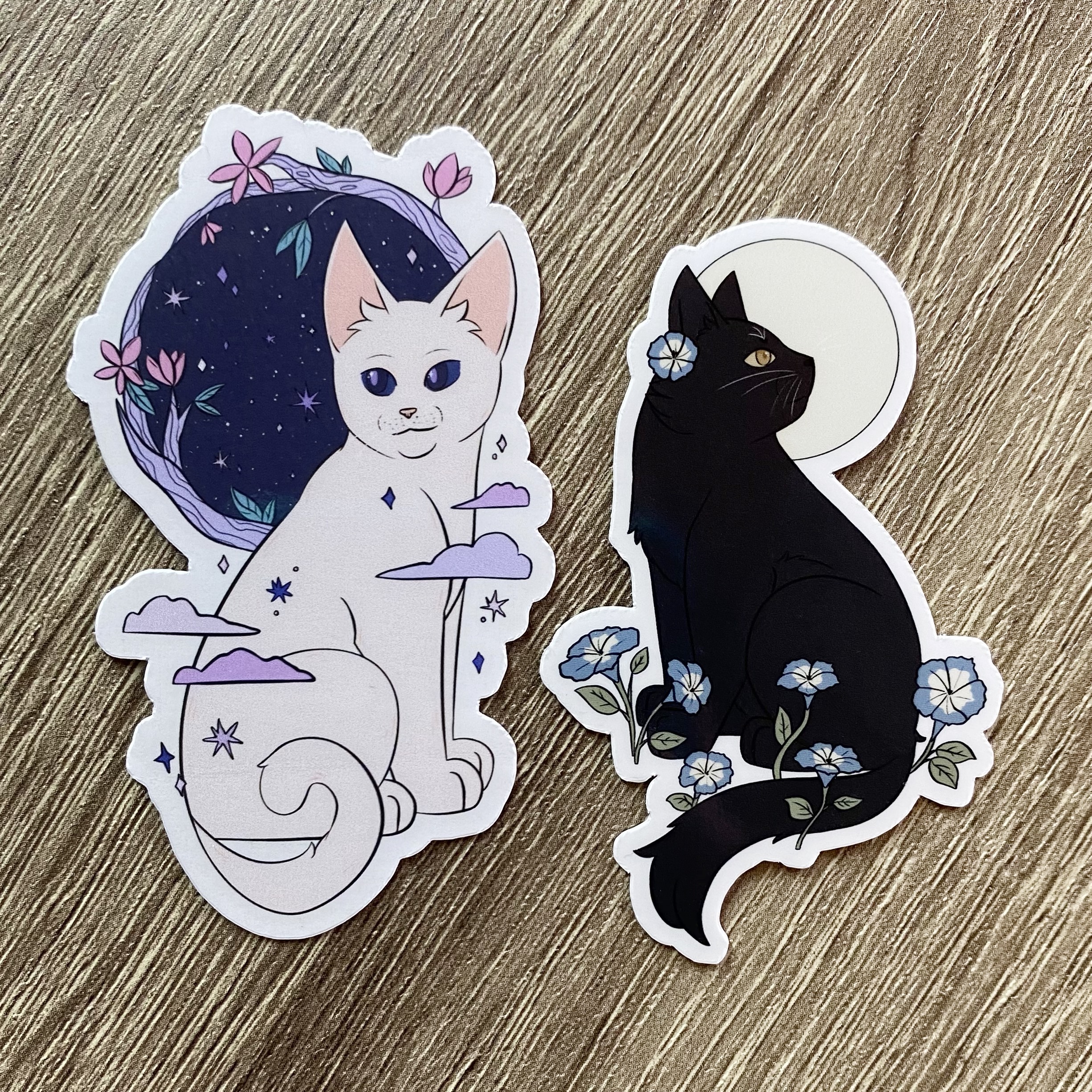 Starblossom and Moonflower Cat Stickers: Glossy stickers of a white cat with stars and flowers and a black cat with the moon and flowers
